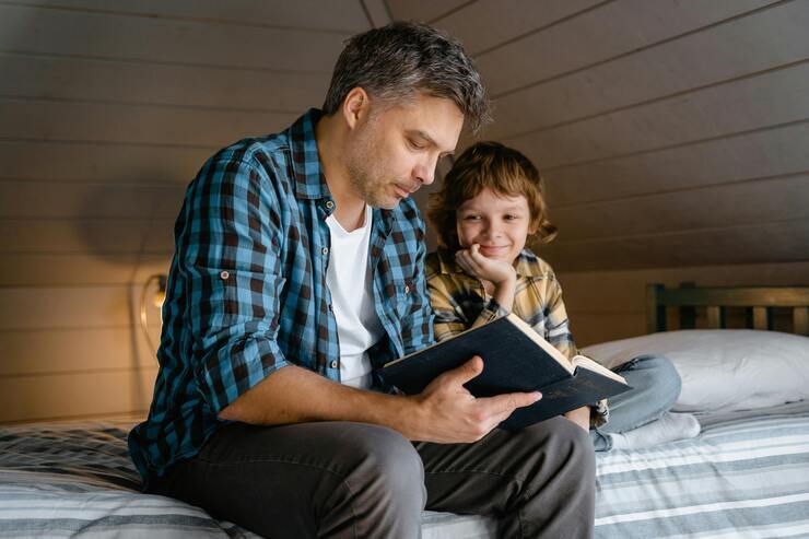 Papà che legge un libro al figlio piccolo